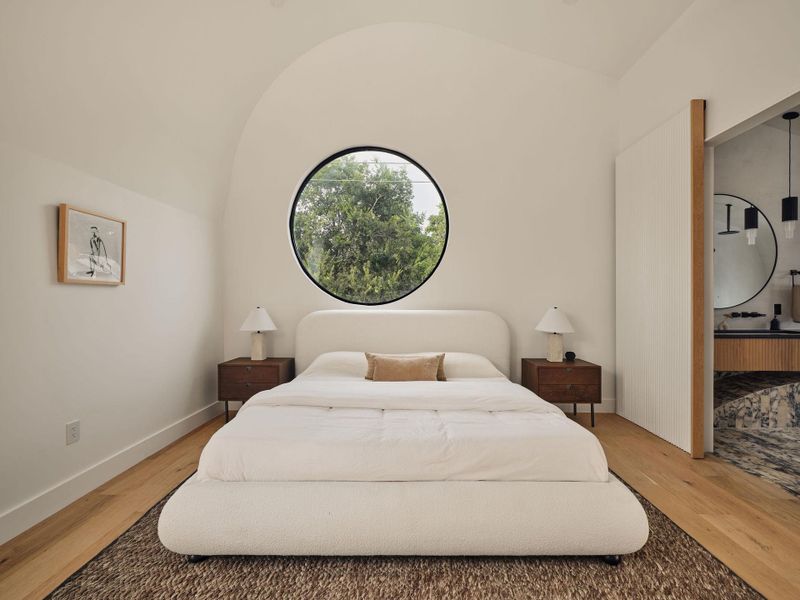 Bedroom featuring vaulted ceiling and light wood flooring Bedroom featuring vaulted ceiling and light wood flooring