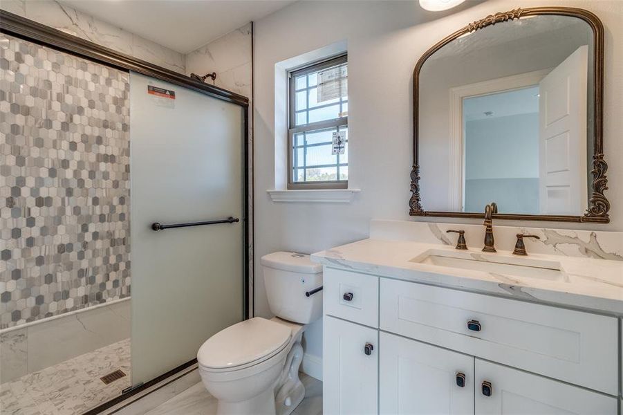 Bathroom with a shower with shower door, toilet, and vanity