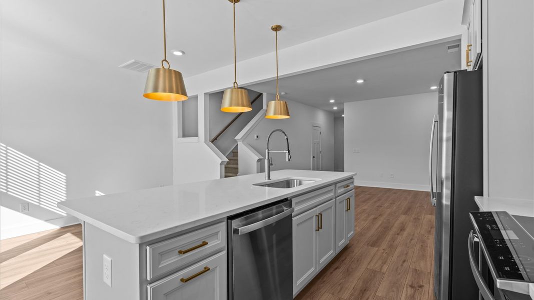 Memorable meals begin in this vibrant kitchen with pendant lighting and a thoughtfully designed island