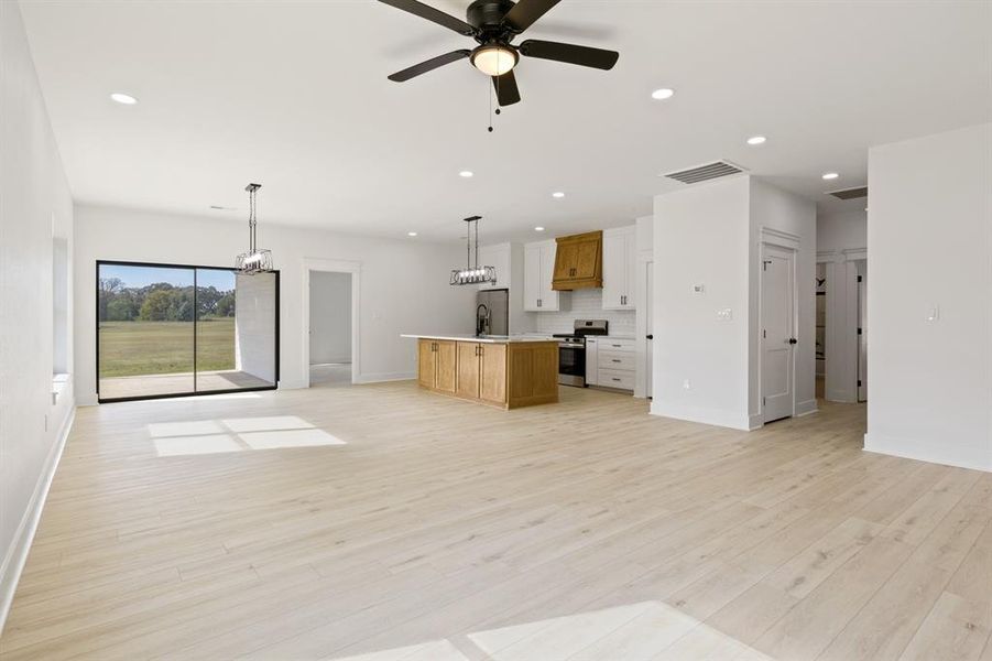 Unfurnished living room featuring recessed lighting, light wood finished floors, and a ceiling fan