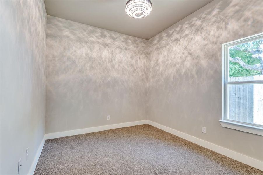 Carpeted spare room featuring baseboards