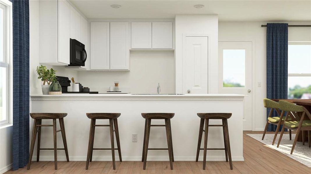 Kitchen with sink, a breakfast bar, white cabinets, and light wood-type flooring