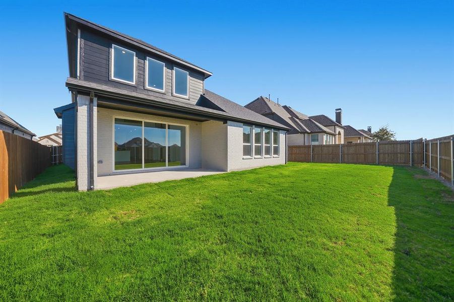 Back of house featuring brick siding, a fenced backyard, and a patio area Back of house featuring brick siding, a fenced backyard, and a patio area