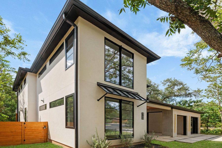 Clean modern architectural lines frame this multi-level exterior under mature shade trees.
