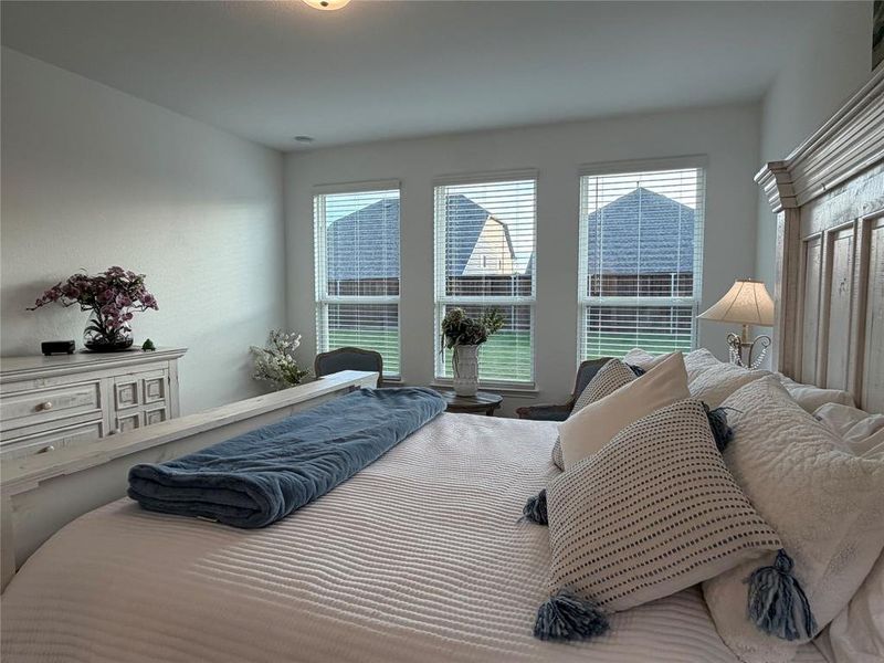 Primary Bedroom with Sitting Area by Wall of Windows