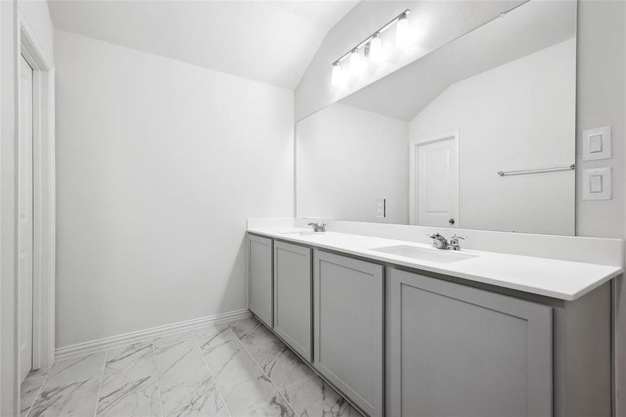 Bathroom featuring vanity and lofted ceiling