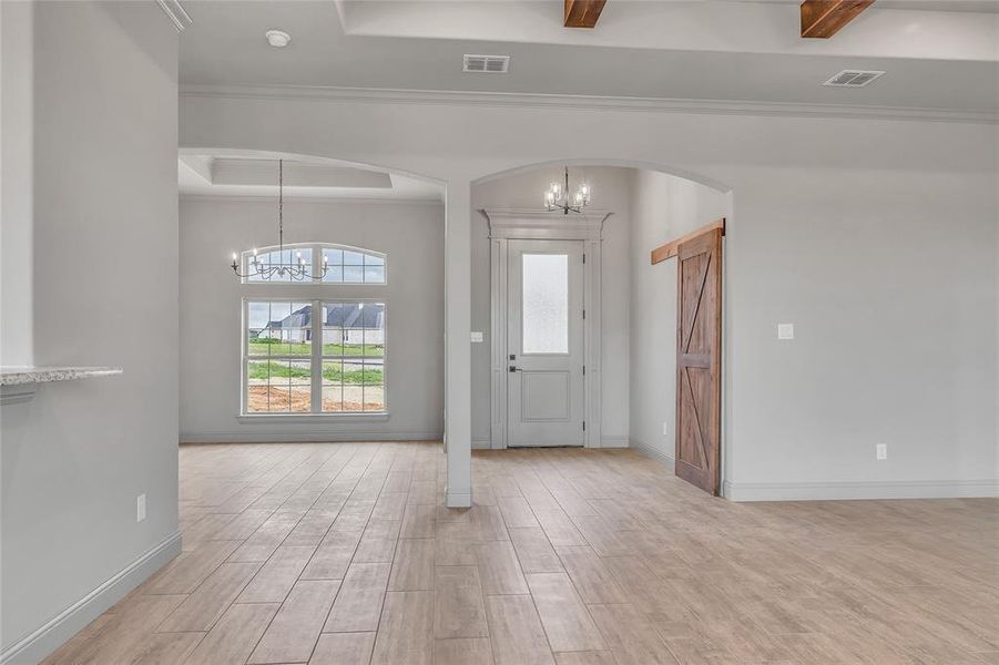 Entrance foyer featuring ornamental molding, light hardwood / wood-style flooring, and a chandelier