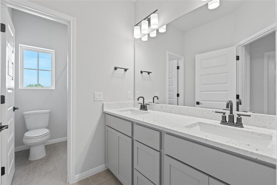 Full bathroom featuring double vanity and tile patterned flooring