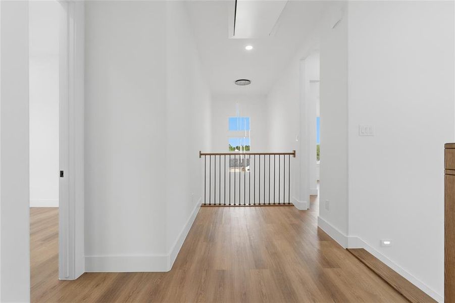 Corridor with light wood-style floors and recessed lighting