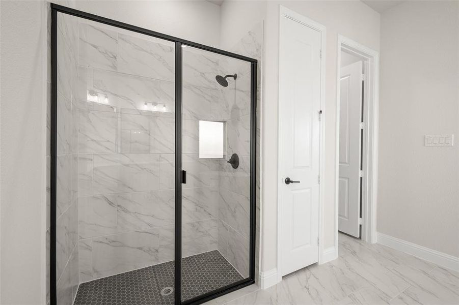 Separate shower with glass door.