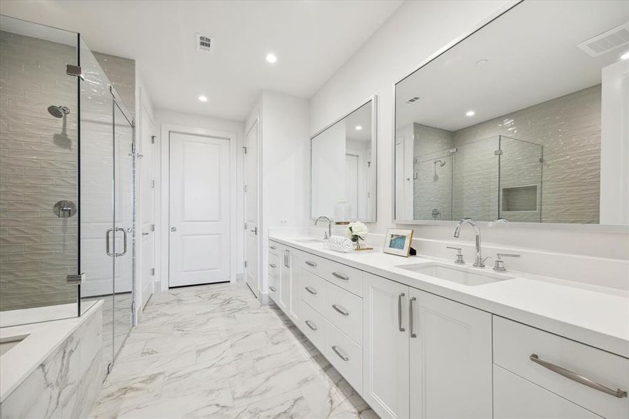 The primary bath is gorgeous with a walk-in shower, Toto toilet, linen closet, and connects to the large custom-built primary closet with vanity.