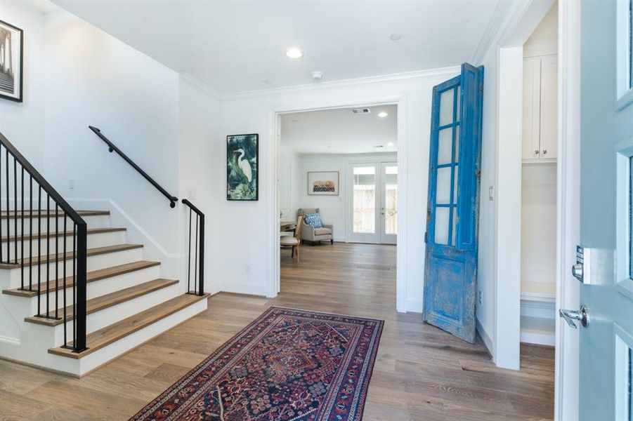 The front foyer is like a room flooded with light from the open stairwell and a convenient mud room with cabinets to the right.