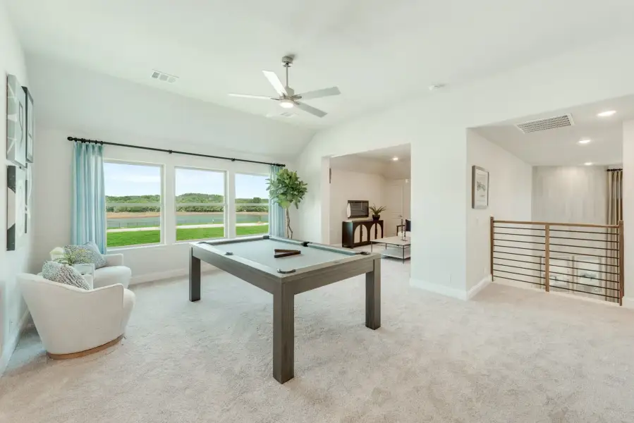 Upstairs game room with pool table, vaulted ceiling, ceiling fan, and large windows with outdoor views