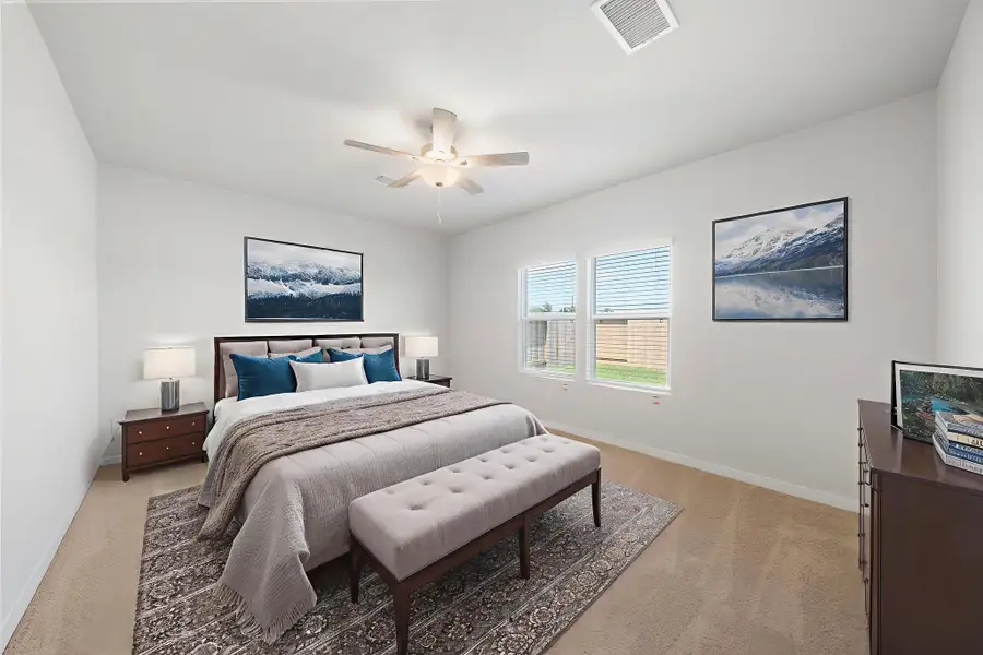 A bedroom with a bed and a bench.