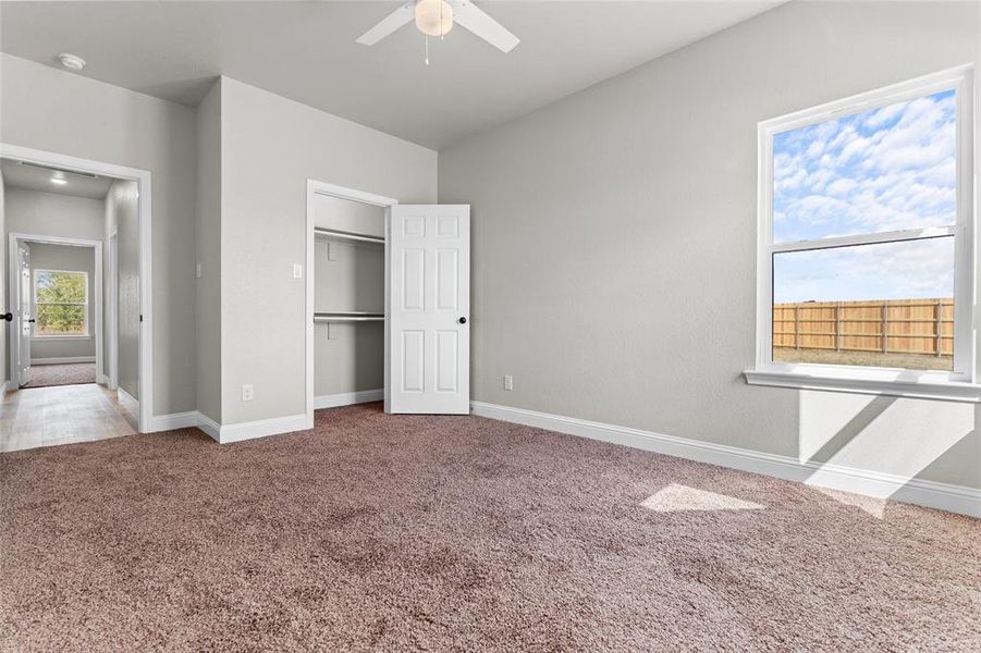 Unfurnished bedroom featuring carpet, a closet, and a ceiling fan