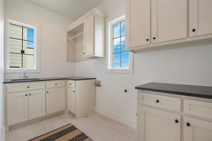 Laundry Room with side-by-side washer and dryer connection plus sink, drying rack, and ample storage