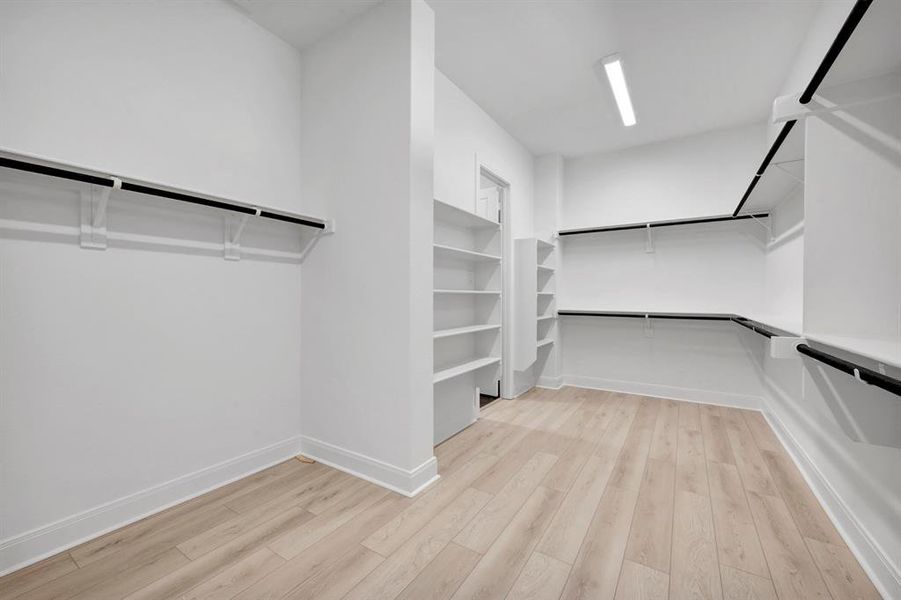 Walk in closet featuring light wood-style floors Walk in closet featuring light wood-style floors