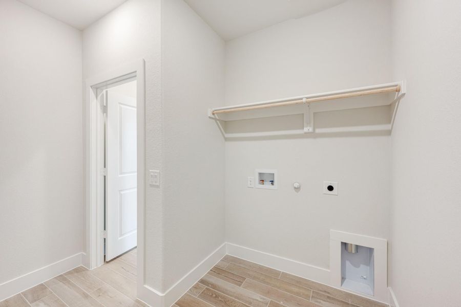 Laundry room with wall shelf, washer and dryer hookups, gas connection, and wood-look tile floor