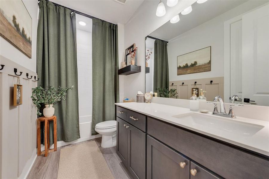 Bathroom featuring a single vanity with a white countertop, chrome faucet, and integrated rectangular sink
