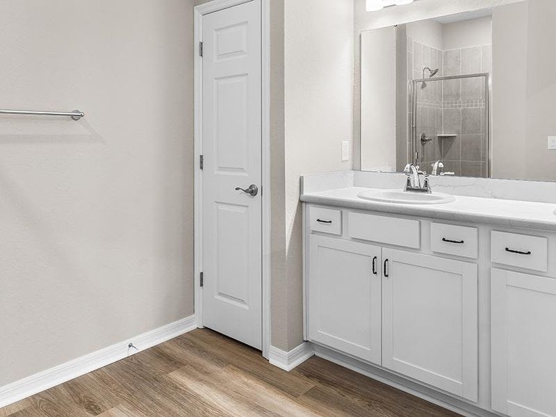 The en-suite bath includes a decorative tiled shower, dual vanities, and a closeted toilet.