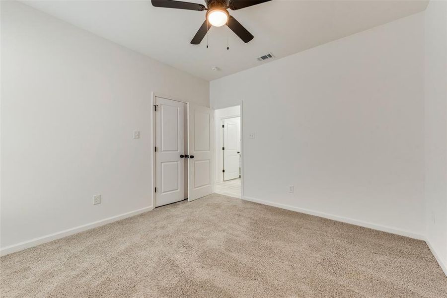 Carpeted empty room with ceiling fan