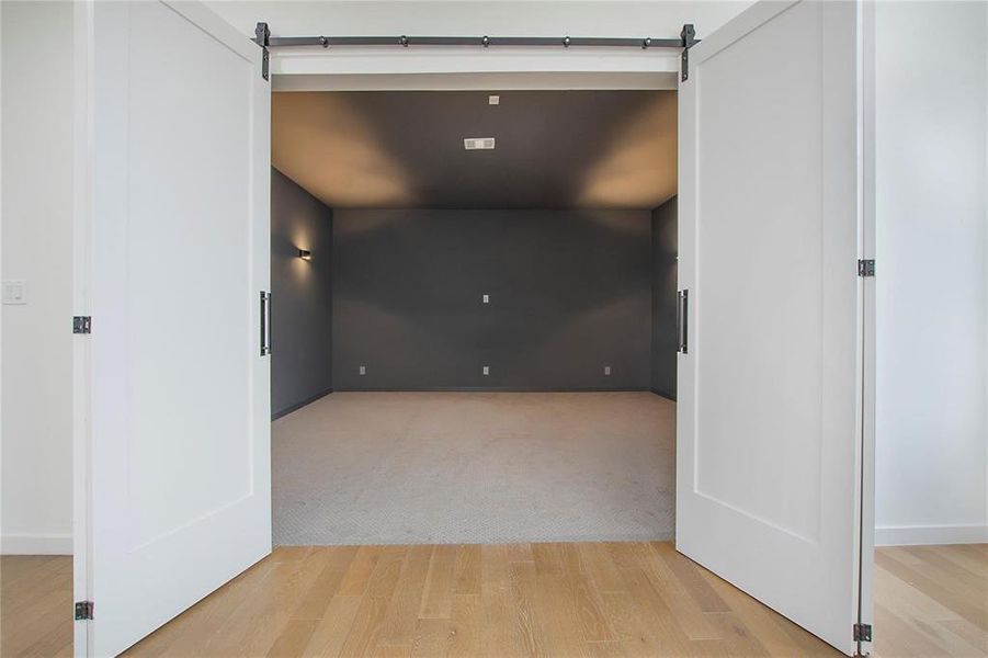 Hall featuring light wood-type flooring and a barn door