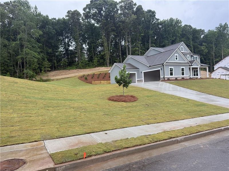 Front exterior of a new home in Woodland Hills, Loganville, GA, highlighting curb appeal (Image 2). Front exterior of a new home in Woodland Hills, Loganville, GA, highlighting curb appeal (Image 2).