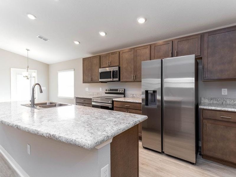 Your new kitchen includes 36-in. cabinets, Samsung SS appliances, and a walk-in pantry - New home for sale in Eagle Lake, FL