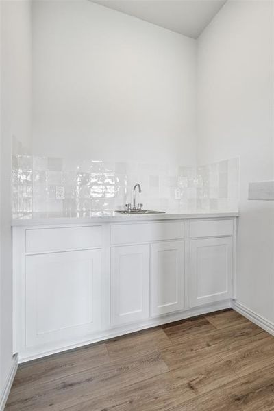 Bathroom featuring vanity, light wood-style floors, and tasteful backsplash