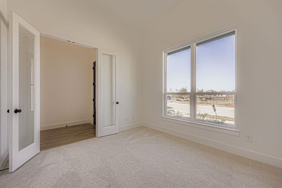 Unfurnished bedroom featuring light colored carpet and baseboards