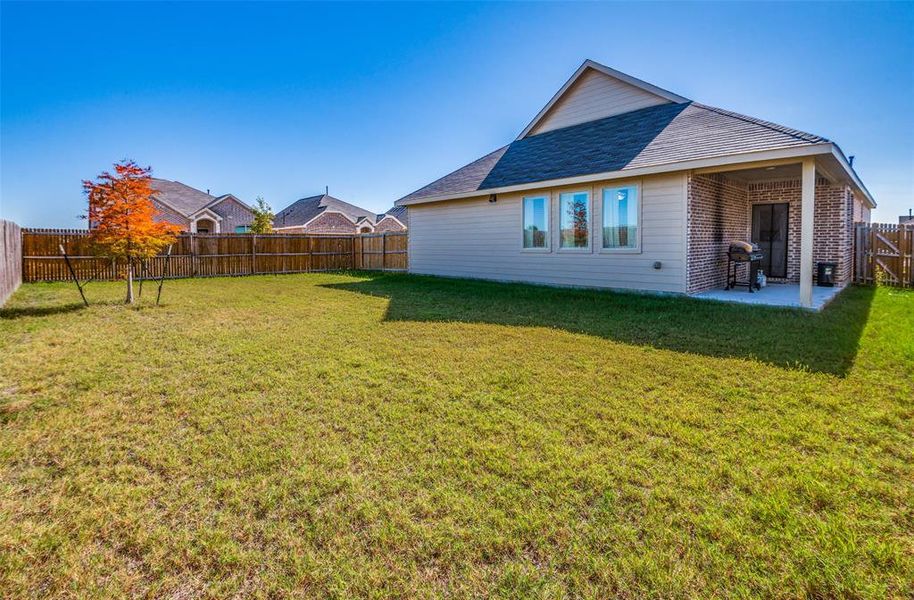 Back of property featuring a lawn and a patio area