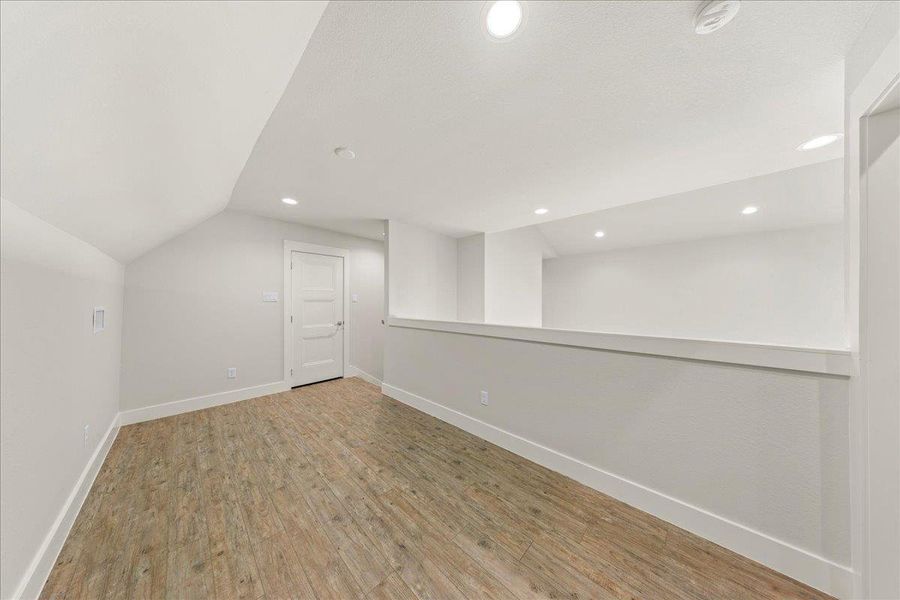 Bonus room with vaulted ceiling, wood finished floors, and recessed lighting Bonus room with vaulted ceiling, wood finished floors, and recessed lighting