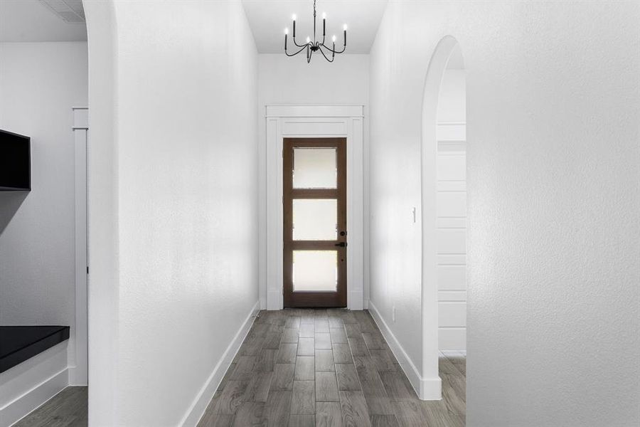 Entryway with a chandelier and dark hardwood / wood-style floors