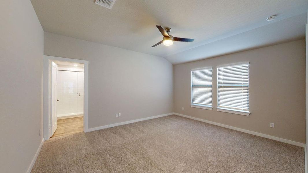 Comfortable carpeted bedroom with a modern ceiling fan, offering a tranquil retreat. Comfortable carpeted bedroom with a modern ceiling fan, offering a tranquil retreat.