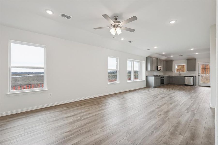 Unfurnished living room with recessed lighting, light wood-type flooring, plenty of natural light, and ceiling fan