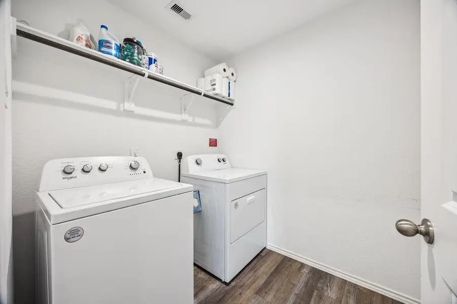 Spacious laundry room featuring modern appliances and ample shelving for storage. Spacious laundry room featuring modern appliances and ample shelving for storage.
