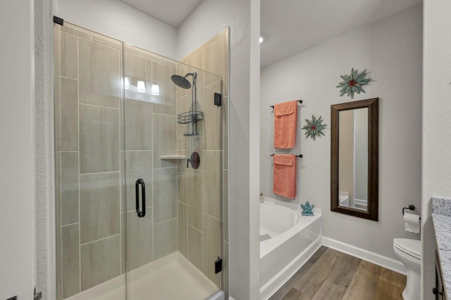 Spa-inspired primary bath featuring a soaking tub, oversized glass-enclosed walk-in shower, and modern finishes for a relaxing retreat. Spa-inspired primary bath featuring a soaking tub, oversized glass-enclosed walk-in shower, and modern finishes for a relaxing retreat.