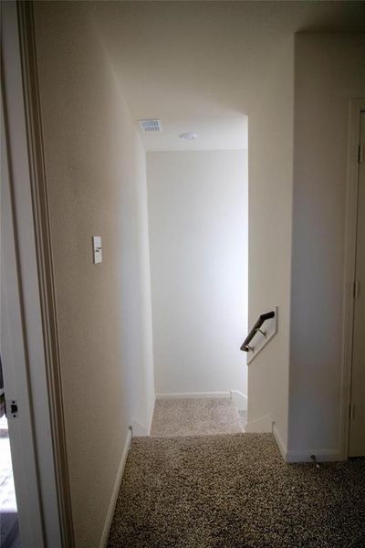 Corridor featuring carpet flooring and baseboards