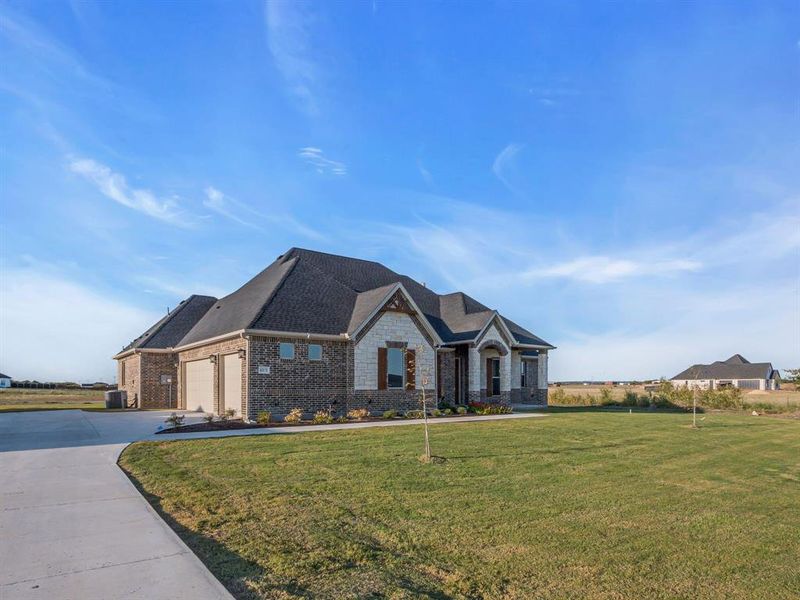 Craftsman inspired home with a front yard, central AC unit, and a garage