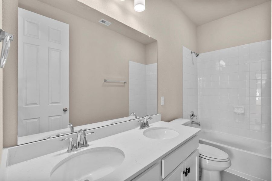 The secondary bath features tile flooring, white cabinetry and light countertops and a shower/tub combo. Perfect for accommodating any visiting family and friends. The secondary bath features tile flooring, white cabinetry and light countertops and a shower/tub combo. Perfect for accommodating any visiting family and friends.