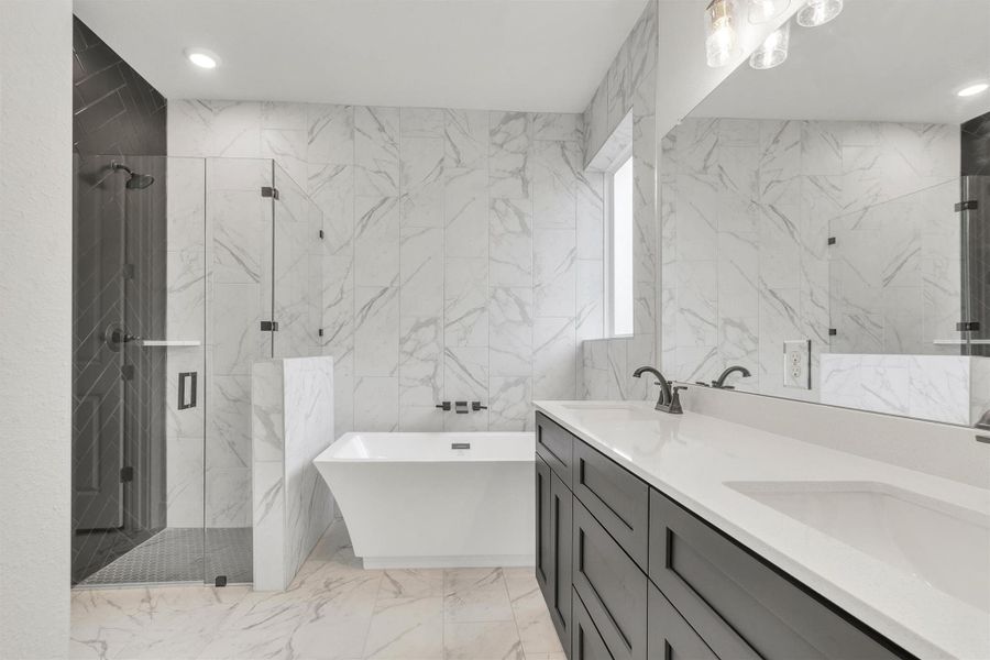 Luxurious bathing quarters feature a freestanding tub, separate glass shower, and a broad dual-sink vanity.