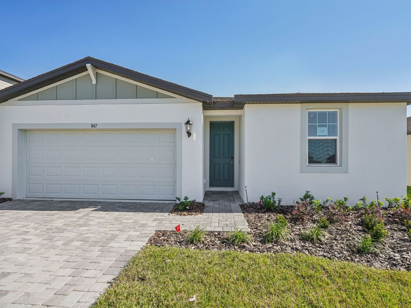 Front exterior of a new home in The Reserve at Hammock Oaks - Signature Series, Lady Lake, FL, highlighting curb appeal (Image 1).