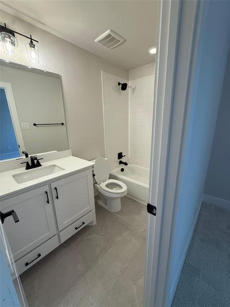 Full bath featuring vanity, shower / bath combination, and a textured wall Full bath featuring vanity, shower / bath combination, and a textured wall