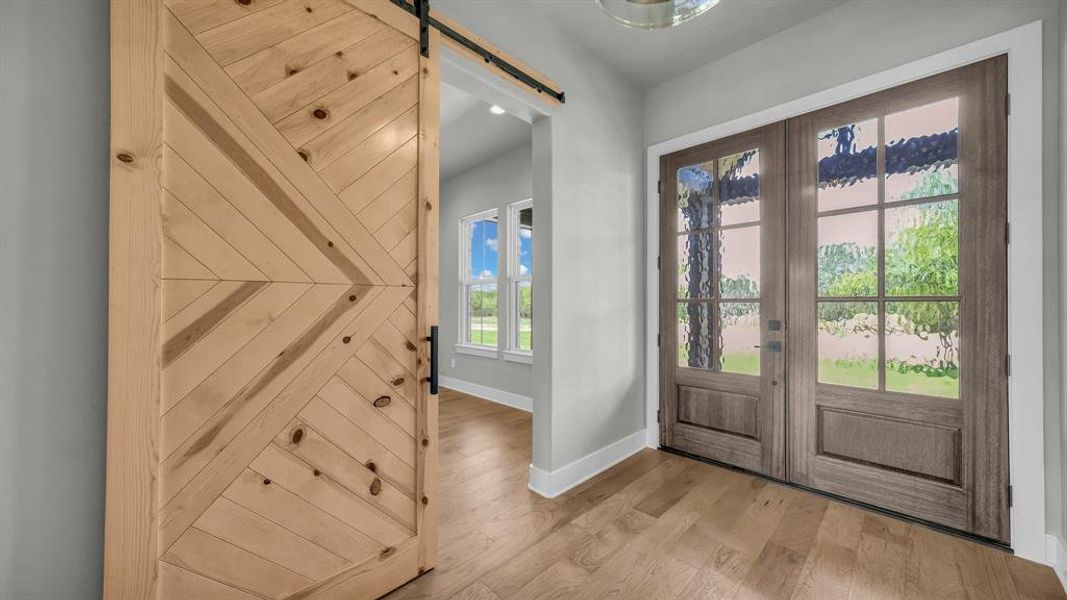 Double entry doors with decorative glass panels and wood-finish flooring