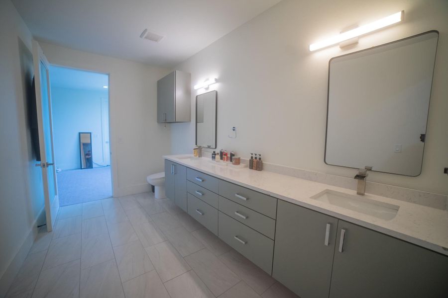 Experience a rare level of architectural harmony throughout the entire home. A meticulously curated palette of countertops, and custom cabinetry flows seamlessly from the kitchen to every bathroom, creating a sophisticated and unified aesthetic in every corner