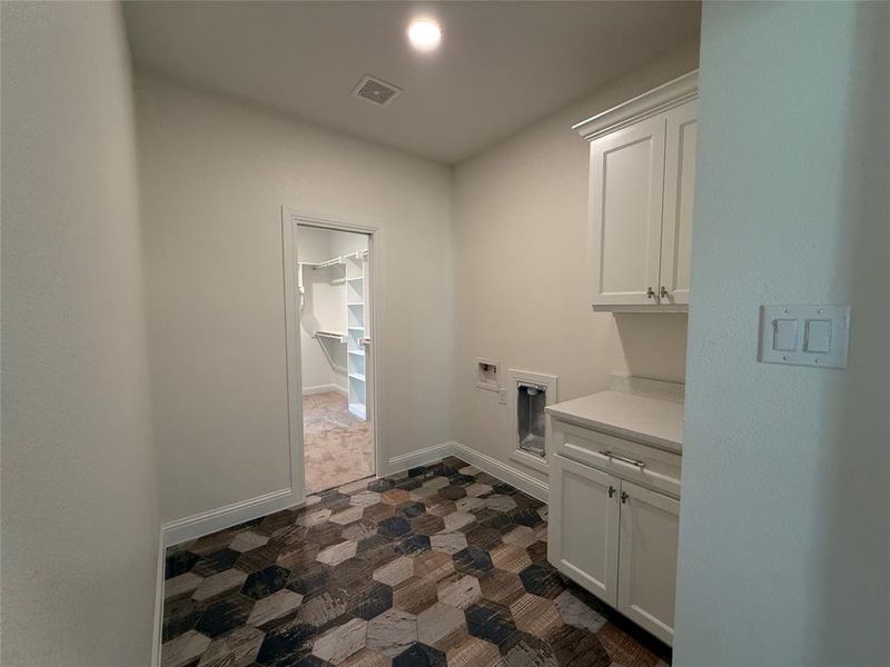 Handy counter space in a dedicated utility room with plenty of cabinet storage.