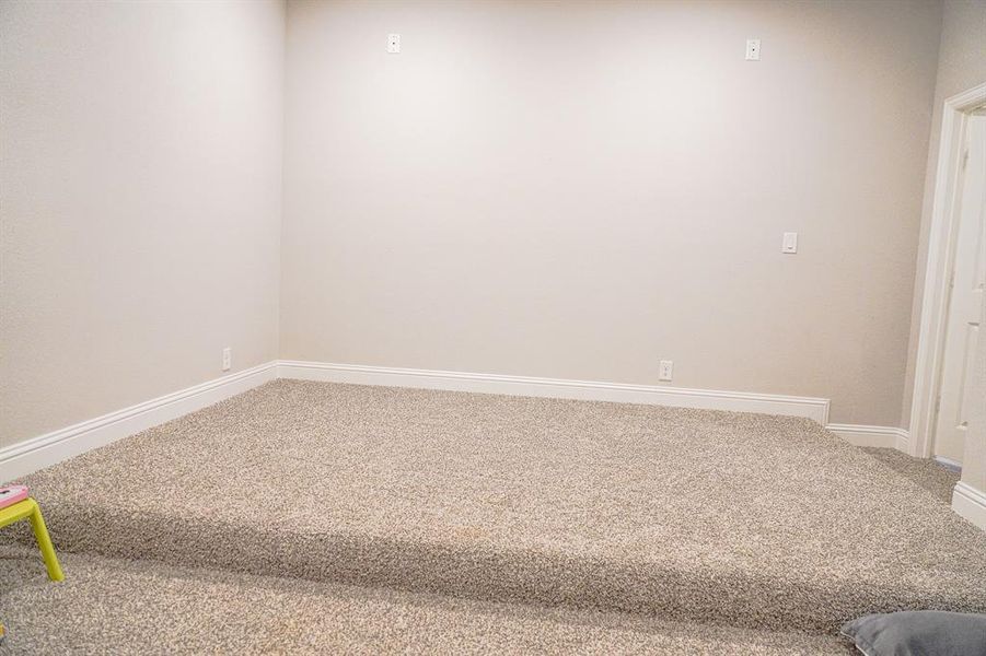 Spare room featuring carpet floors and baseboards