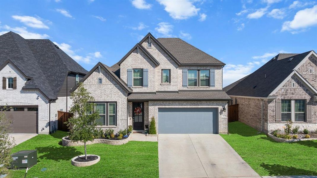 View of front of house with brick siding, driveway, roof with shingles, and a garage View of front of house with brick siding, driveway, roof with shingles, and a garage