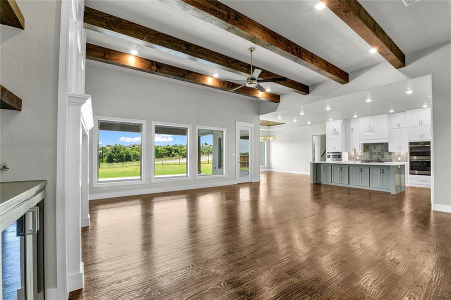 Unfurnished bedroom with ceiling fan, a closet, multiple windows, and dark hardwood / wood-style flooring