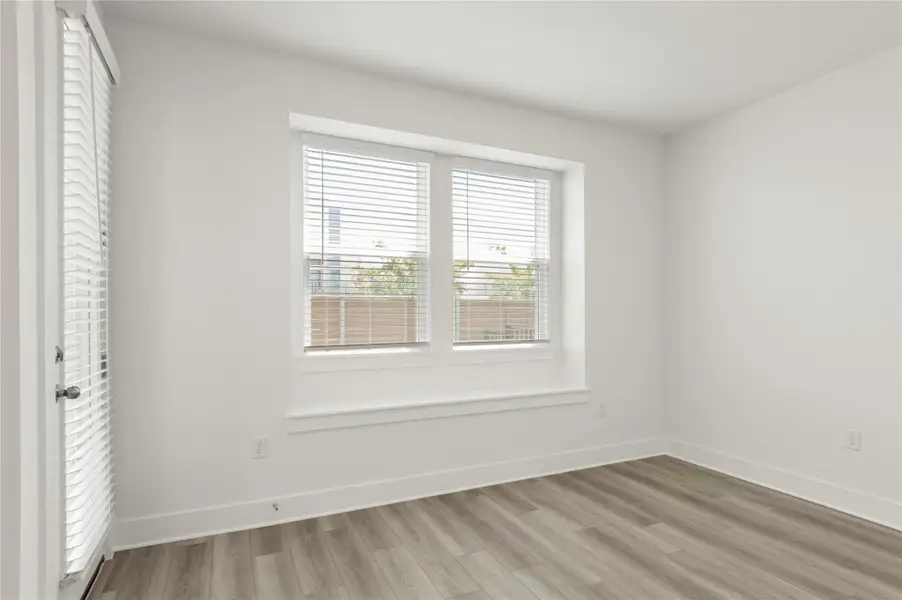 Unfurnished bedroom featuring light wood finished floors and baseboards